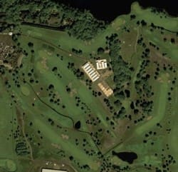 A satellite image of a golf course with trees.